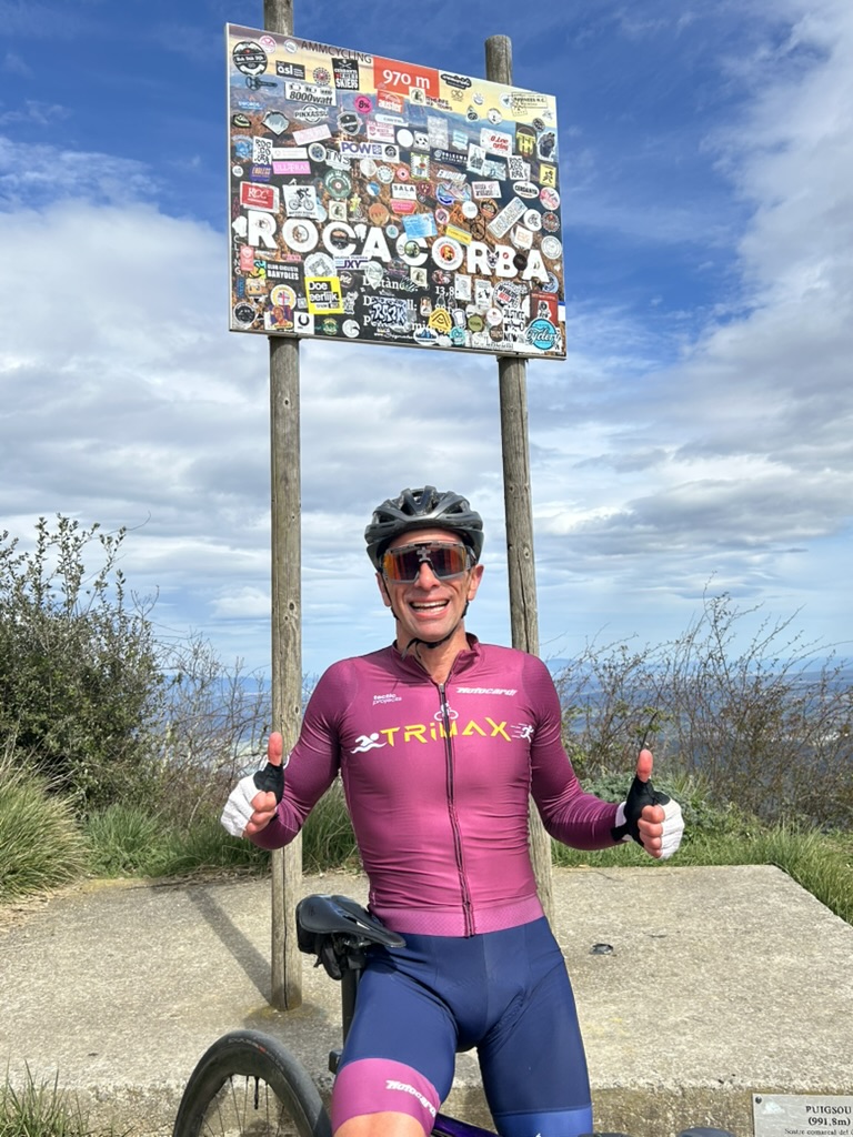 Cyclist at the Rocacorba summit sign, 970 m, above Girona