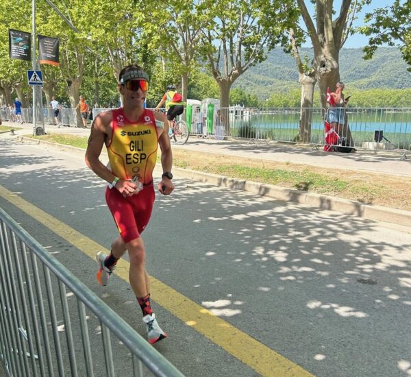 Triathlete running along the promenade at Lake Banyoles during a race
