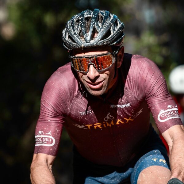 TRIMAX cyclist racing hard on a dusty gravel course