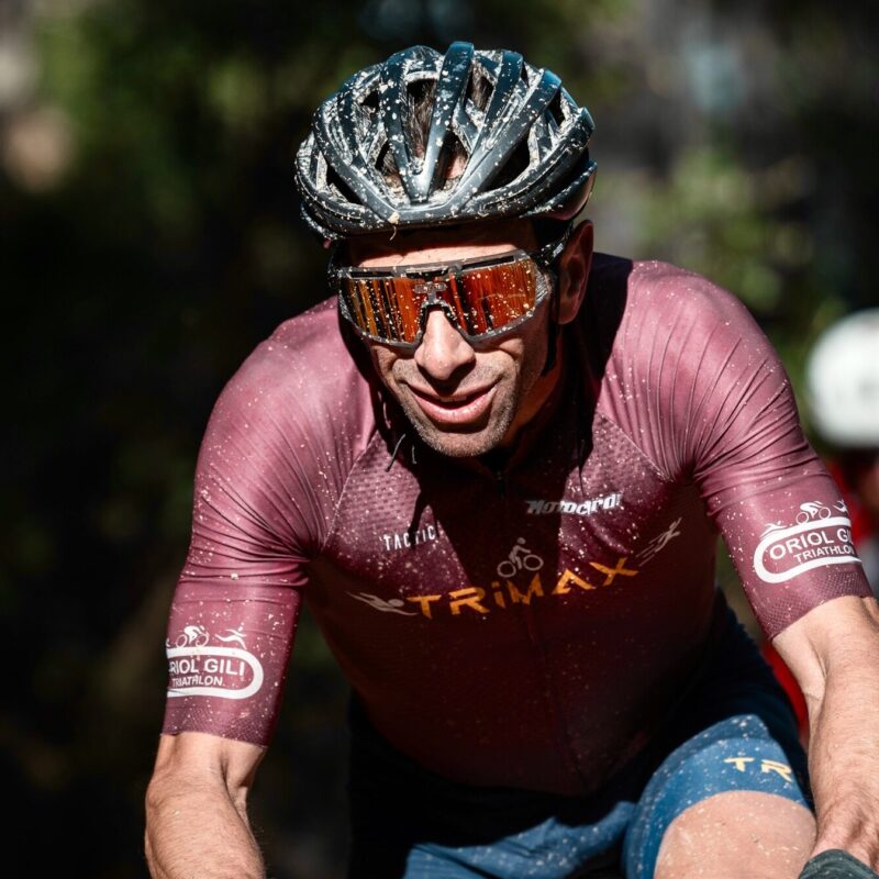 TRIMAX cyclist racing hard on a dusty gravel course